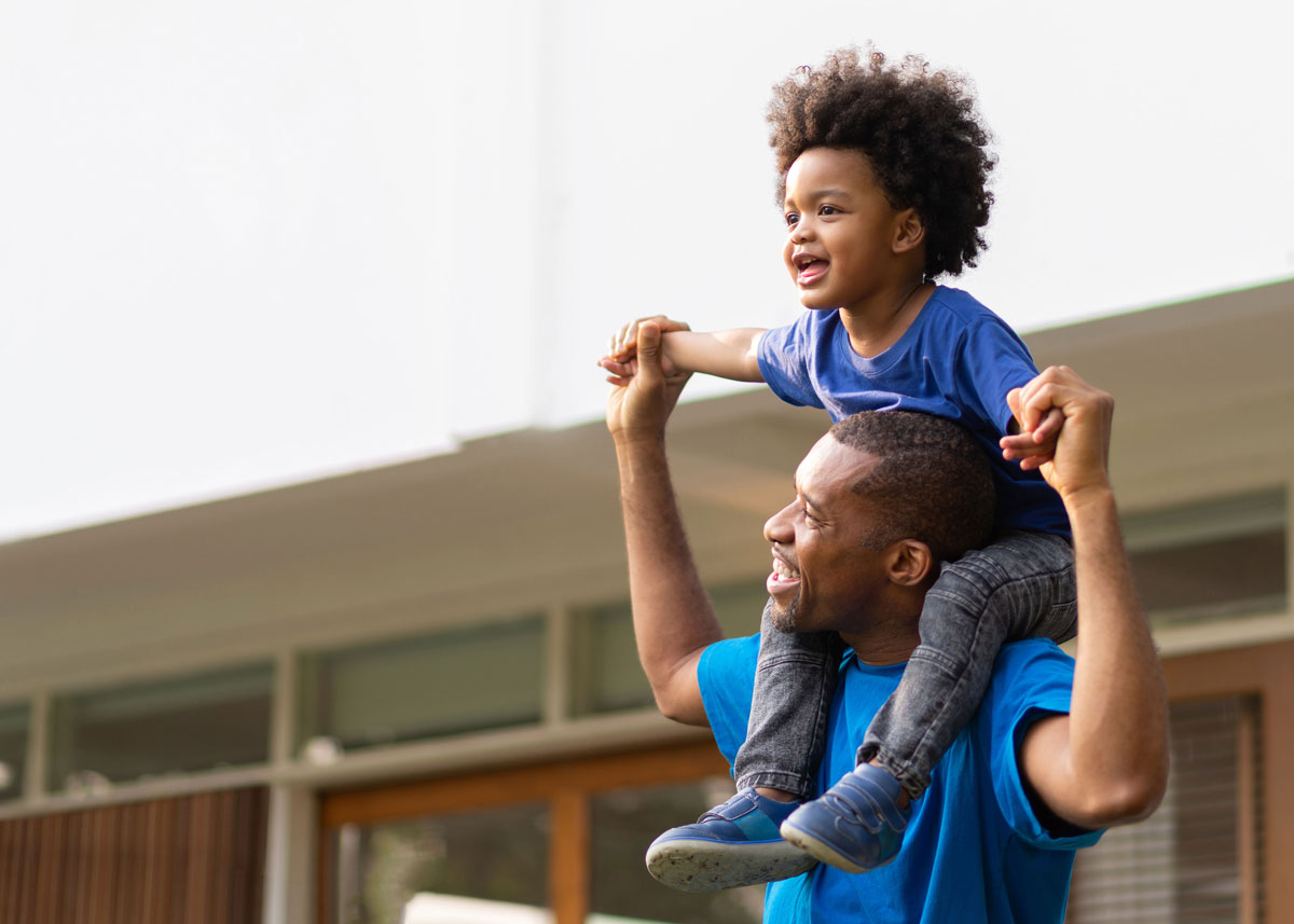 A man carrying a smiling boy on his shoulders