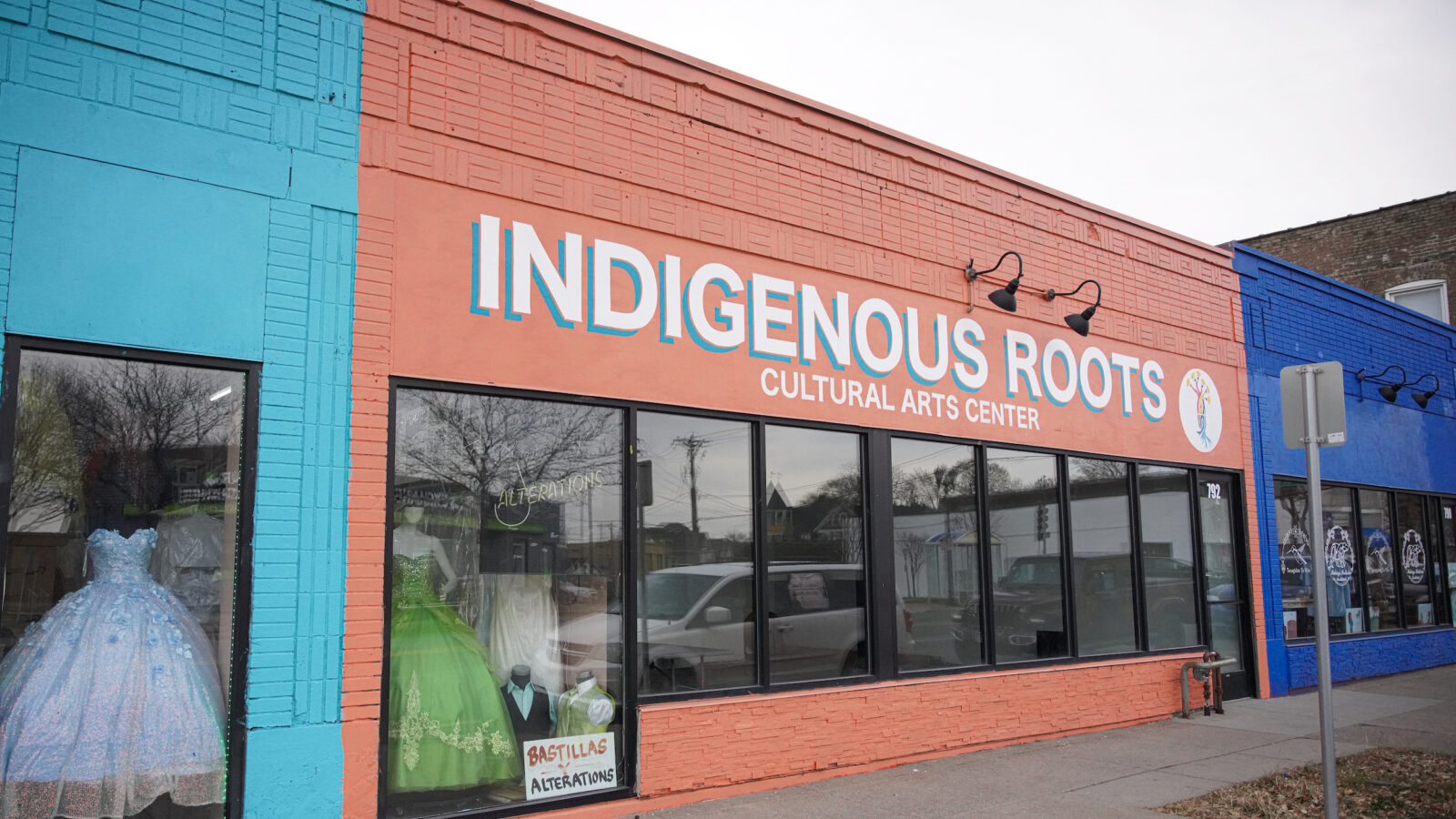 A multi-colored storefront with lettering that reads 'Indigenous Roots Cultural Arts Center'.