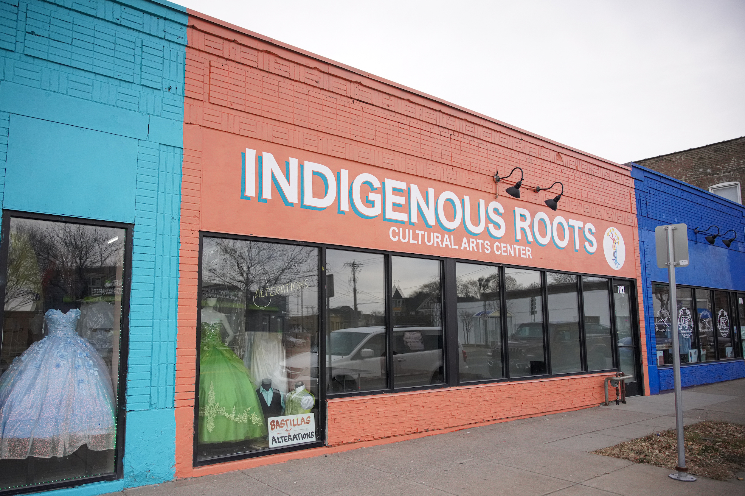 A multi-colored storefront with lettering that reads 'Indigenous Roots Cultural Arts Center'.